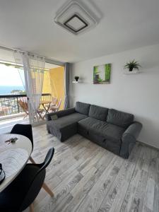 a living room with a couch and a table at Lookout Point Tenerife Holiday Apartment Las Americas in Playa Fañabe