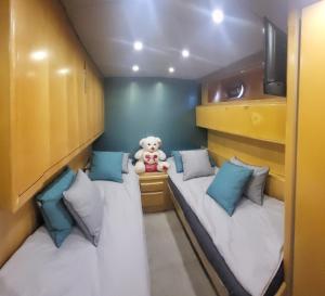 two beds in a small room with a teddy bear at Hébergement Yacht in Cogolin