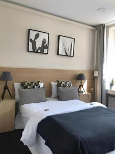 um quarto com uma cama grande com três fotografias na parede em Sleephotels em Hamburgo