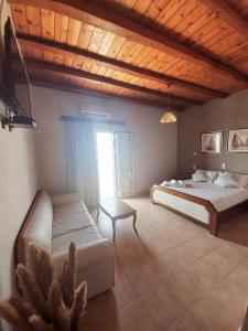 a bedroom with a bed and a couch and a window at Agia Roumeli Hotel in Agia Roumeli