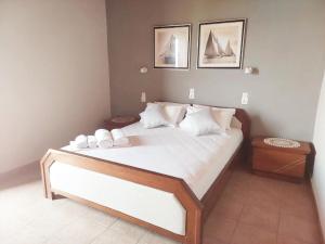 sypialnia z dużym łóżkiem z białą pościelą i poduszkami w obiekcie Agia Roumeli Hotel w mieście Ajia Rumeli