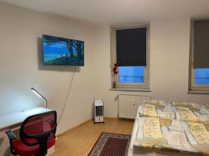 a bedroom with a bed and a desk and a chair at Appartement Trier Zentrum ( mit Mosel Blick ) in Trier