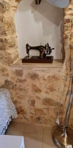uma mesa com uma máquina de costura numa parede em Village home em Quios