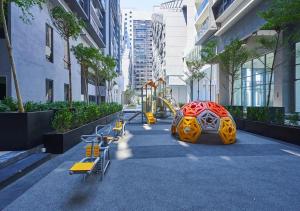 a playground in a city with yellow and red swings at Imperio Melaka Standard Suites by Jeffery Lam Home Management in Melaka
