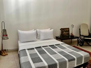 1 dormitorio con 1 cama con almohadas blancas y silla en Monastiraki Loft AthensApart en Atenas