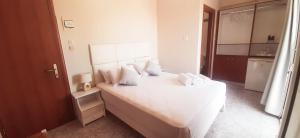 a bedroom with a bed with white sheets and pillows at Agia Roumeli Hotel in Agia Roumeli
