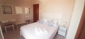 a bedroom with a white bed with two towels on it at Agia Roumeli Hotel in Agia Roumeli