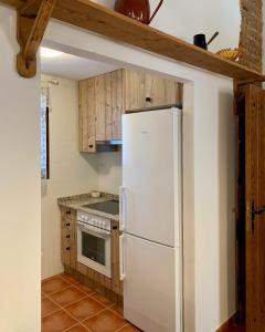 a kitchen with a white refrigerator and wooden cabinets at Casa Monegros in Lastanosa