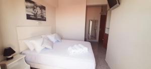 a bedroom with a white bed with white pillows at Agia Roumeli Hotel in Agia Roumeli