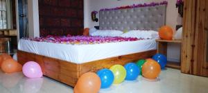 a bed with balloons and a bunch of balloons around it at Sara green Valley Farm in Mahabaleshwar
