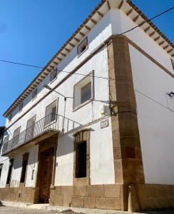 a white building with a balcony on the side at Casa Monegros in Lastanosa