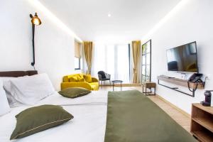 a bedroom with a large bed and a yellow couch at Olive Villas Beach Hotel in Sozopol