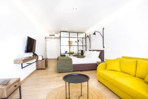 a living room with a yellow couch and a bed at Olive Villas Beach Hotel in Sozopol