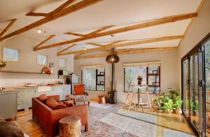 a living room with a couch and a table at Elsewhere Treehouse and Apartment on the River in Muldersdrift +15 photos