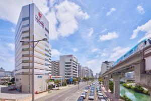 a train on a bridge over a street with cars at Okinawa NaHaNa Hotel & Spa in Naha