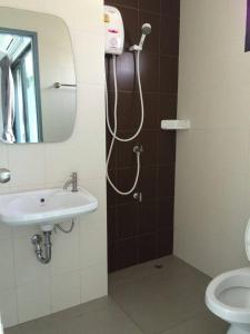 a bathroom with a shower with a sink and a mirror at Promsook Apartment in Bangsaen