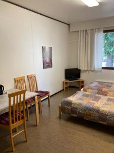 a bedroom with a bed and a table and chairs at Guesthouse - Kuin Kotonaan in Kotka