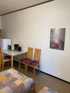 a room with a table and chairs and a table and a kitchen at Guesthouse - Kuin Kotonaan in Kotka