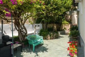 a blue bench sitting in a courtyard with flowers at Villa dei Sogni - Aparthotel Ischia Ponte in Ischia