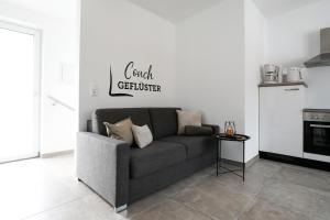 a couch in a living room with a kitchen at Ferienwohnung Dohr in Kundl +23 photos