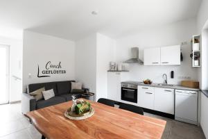 a kitchen and a living room with a wooden table at Alpen Apartment mit Dachterrasse & Parkplatz in Kundl
