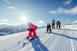 a group of people skiing down a snow covered slope at Alpen Apartment mit Dachterrasse & Parkplatz in Kundl