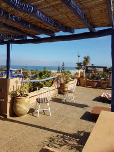 een patio met stoelen en uitzicht op de oceaan bij domaine club Evasion in Tamelalt