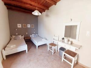 a room with two beds and a desk and a sink at Agia Roumeli Hotel in Agia Roumeli
