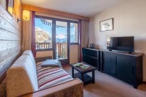 a living room with a couch and a flat screen tv at Résidence Pierre & Vacances Saskia Falaise in Avoriaz