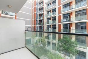 Cet appartement dispose d'un balcon offrant une vue sur un bâtiment. dans l'établissement Posh Studio - Comfort and Peace - Bills Included, à Dubaï