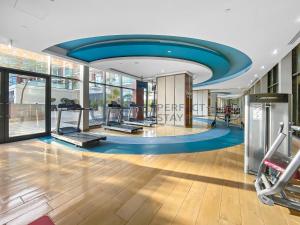 a gym with several treadmills and a blue ceiling at Posh Studio - Comfort and Peace - Bills Included in Dubai