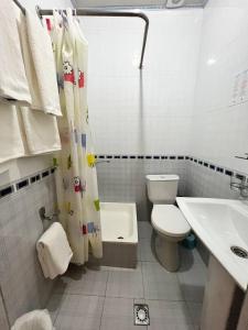 La salle de bains blanche est pourvue de toilettes et d'un lavabo. dans l'établissement Hotel Caravan Serail, à Samarcande