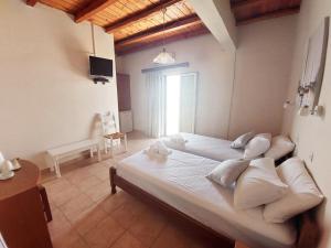 a bedroom with a large bed with white pillows at Agia Roumeli Hotel in Agia Roumeli