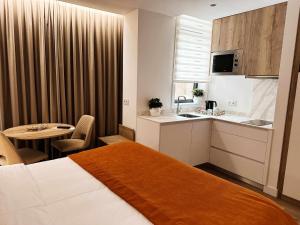 a hotel room with a bed and a kitchen and a table at Coração do Tua Hotel in Mirandela