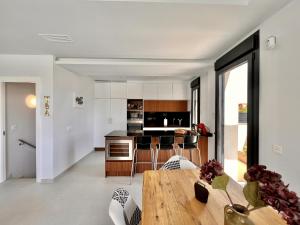 a kitchen and dining room with a wooden table at Cape villa in Cabo de Roig by Perfectly Rentals in Orihuela