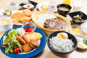 Sotetsu Fresa Inn Nihombashi-Ningyocho في طوكيو: طاولة مع أطباق من الطعام وأوعية من الطعام