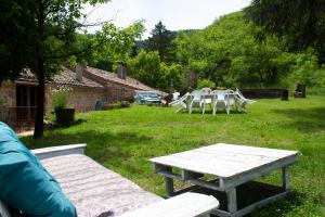 a picnic table and chairs in a yard at Auberge de Lascours in Ceilhes-et-Rocozels