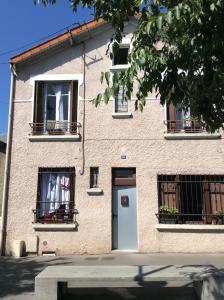 un edificio con ventanas, una puerta blanca y un edificio en Rose, en Villejuif