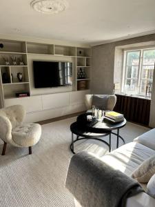 sala de estar con TV, sofá y mesa en Vackert kalkstenshus på Gotland 