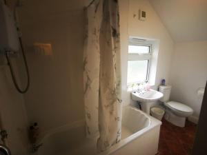 a bathroom with a tub and a toilet and a sink at Twin Room - Sutherland Place in Derby