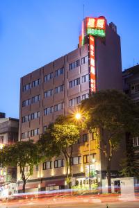 a building with a neon sign on the side of it at Citizen Hotel in Taipei