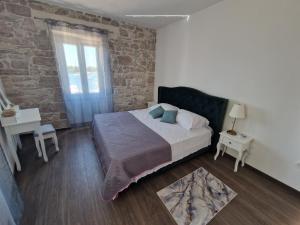 a bedroom with a bed and a brick wall at Villa Galleria in Sukošan