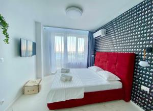 a bedroom with a bed with a red head board at Arena MALL Galleria View and Securities Parking1 in Burgas City