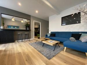 sala de estar con sofá azul y mesa en Appartement 97 M2 proche Puy du fou en Saint-Laurent-sur-Sèvre