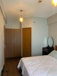 a bedroom with a bed and a mirror and a door at 1BR Condo at Montecito Newport City Residential Resort across NAIA and Marriott Hotel in Manila