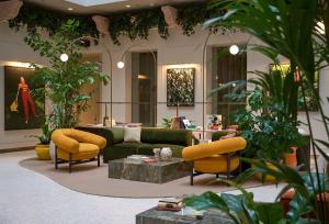 a living room with a couch and chairs and plants at Verno House in Budapest