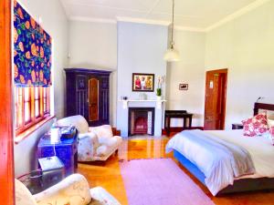 ein Schlafzimmer mit einem Bett und einem Kamin in der Unterkunft Whistlewood Guesthouse Walmer, Port Eizabeth in Port Elizabeth