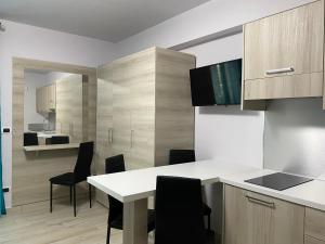 una cocina con armarios de madera, mesa y sillas en La casa dell’Aurora, en Falcone