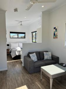 a living room with a couch and a bed at Club Byron Accommodation in Byron Bay