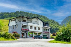 a large white building with a car parked in front at NaturparkResort Xeisblick in Palfau